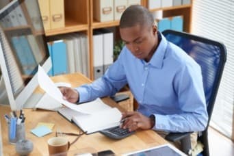 Businessman concentrated on work with financial document - TEC in salary - BizEdge blog