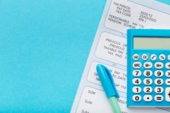 a calculator and a payslip - Payroll management system - BizEdge blog