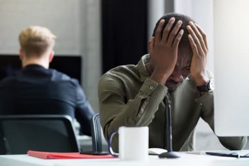 Upset african man with hand on his head - Workplace Investigation - BizEdge blog