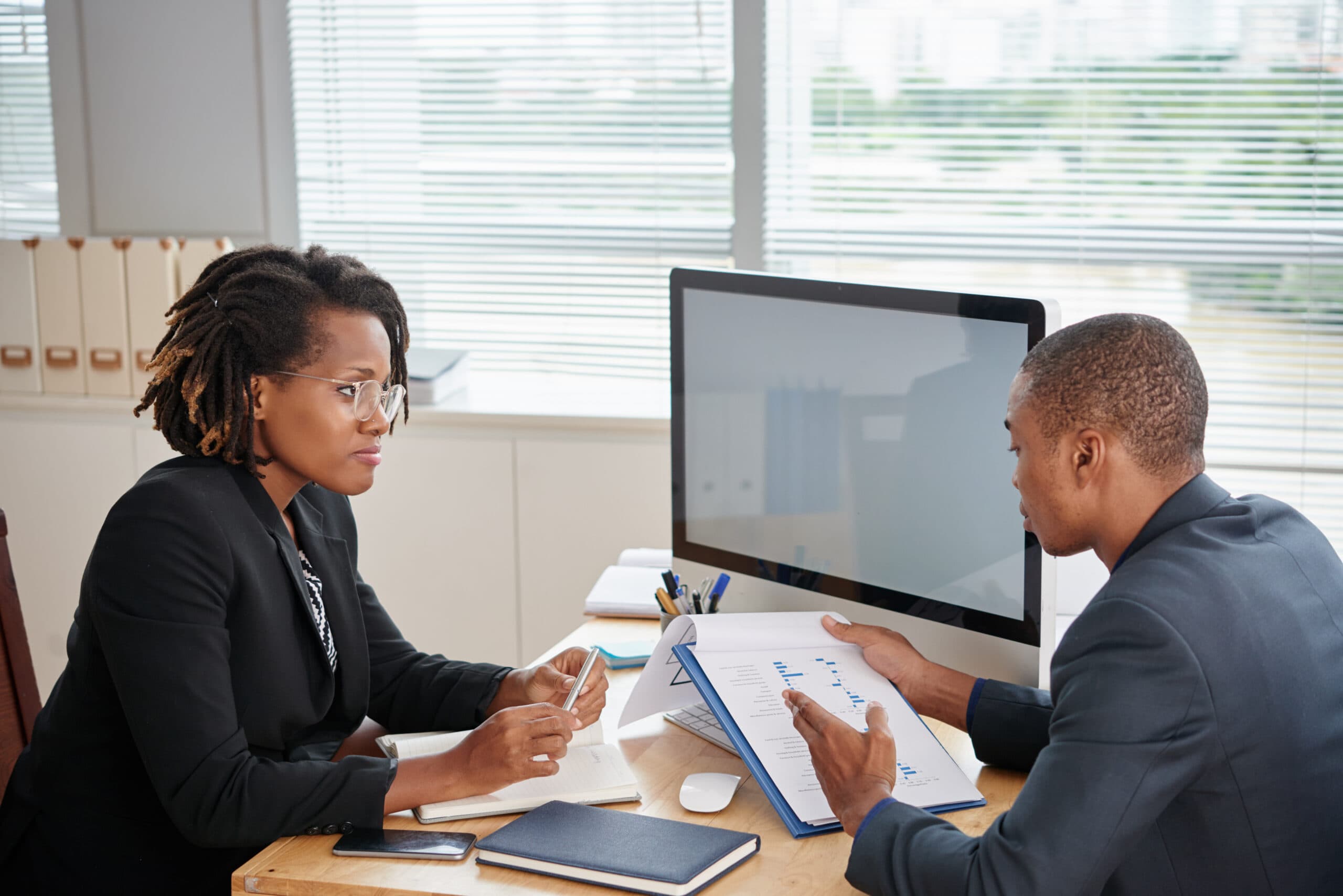Two colleagues discussing - Common Performance Review Mistakes Managers Make (and How to Avoid Them)- BizEdge blog
