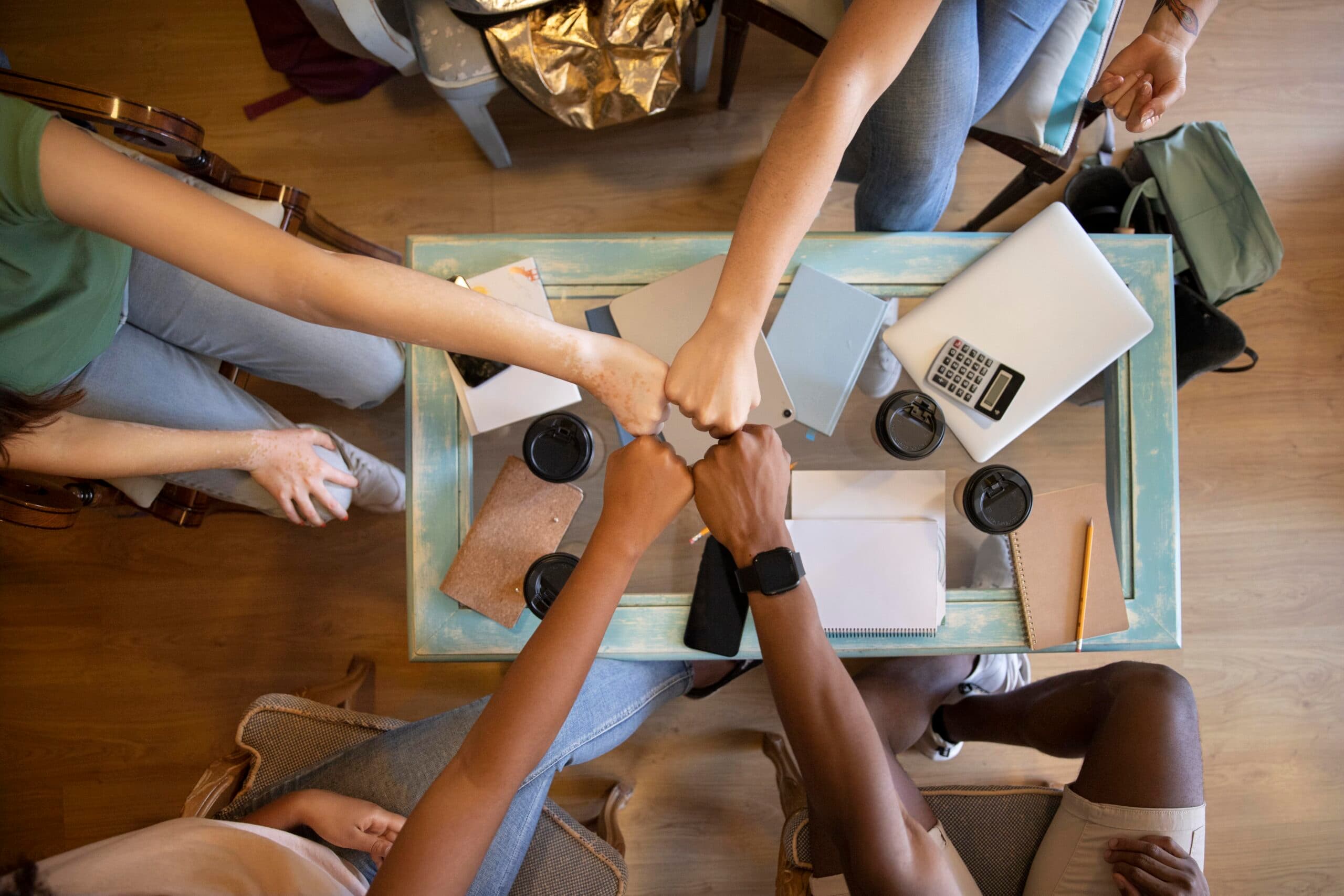 A picture of a group of people fist bumping - 6 Proven Ways to Build a Thriving Workplace Culture - BizEdge blog