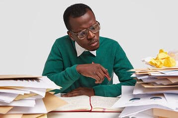 a man on his desk scanning through files- automate hr processes - BizEdge blog