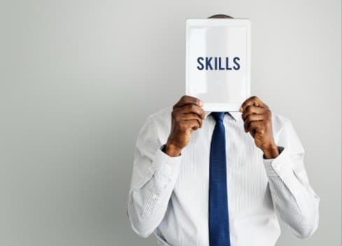 a man holding a pamphlet saying skills written on it - skills gap - BizEdge blog