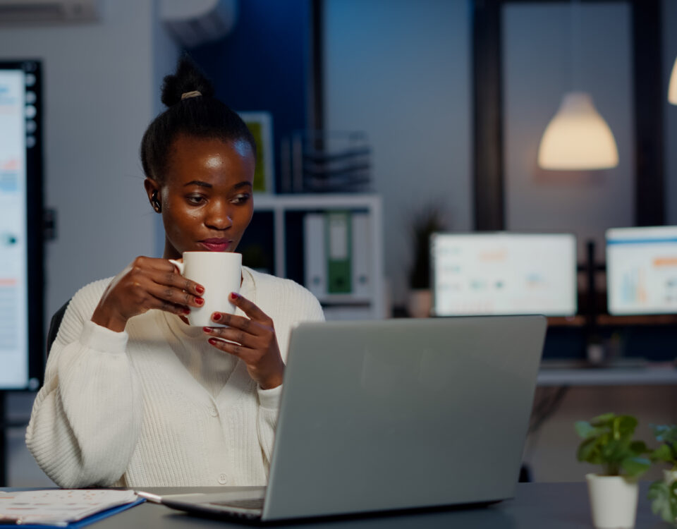 A picture of a woman drinking a coffee during a virtual meeting with team members - How to Boost Productivity with Employee Self-Service Portal - BizEdge post