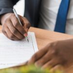 A picture of a man confirming a document - Employeme verification vs. Reference Check - BizEdge post
