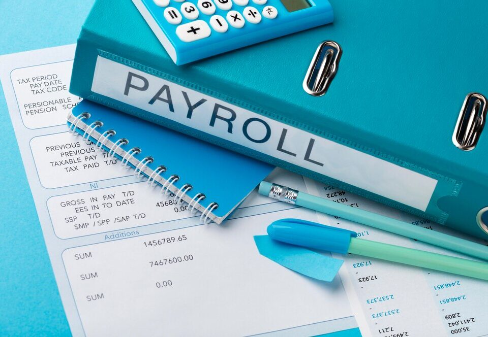 A slip showing gross income, tax and a book named payroll - How to Calculate Your PAYE Tax in Nigeria- BizEdge post