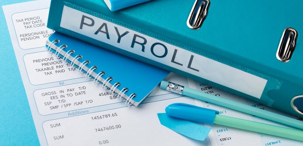 A slip showing gross income, tax and a book named payroll - How to Calculate Your PAYE Tax in Nigeria- BizEdge post