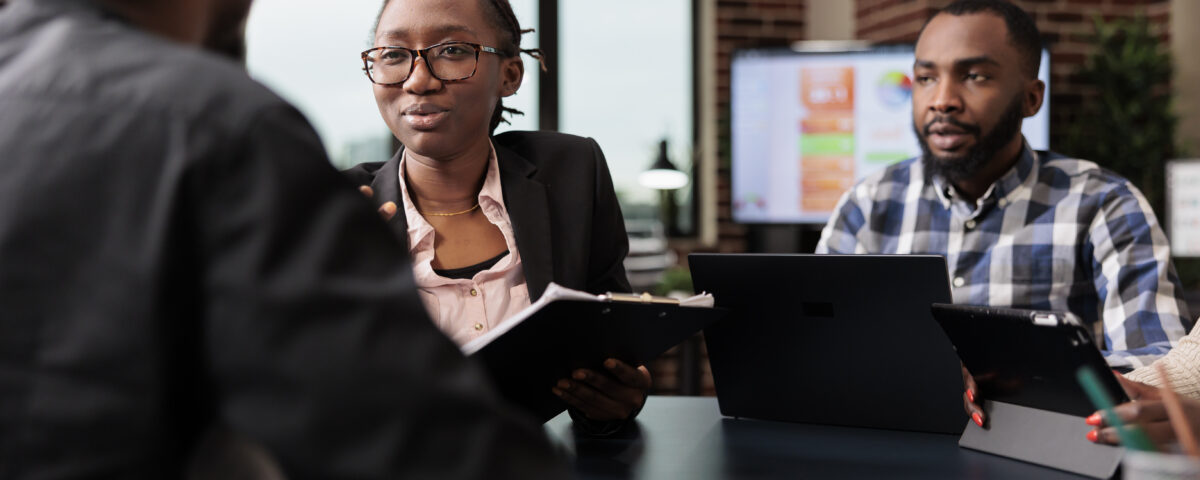 A group of people on a panel table analyzing a document - How to Conduct a Great Employee Reference Check - BizEdge blog
