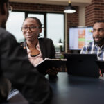 A group of people on a panel table analyzing a document - How to Conduct a Great Employee Reference Check - BizEdge blog