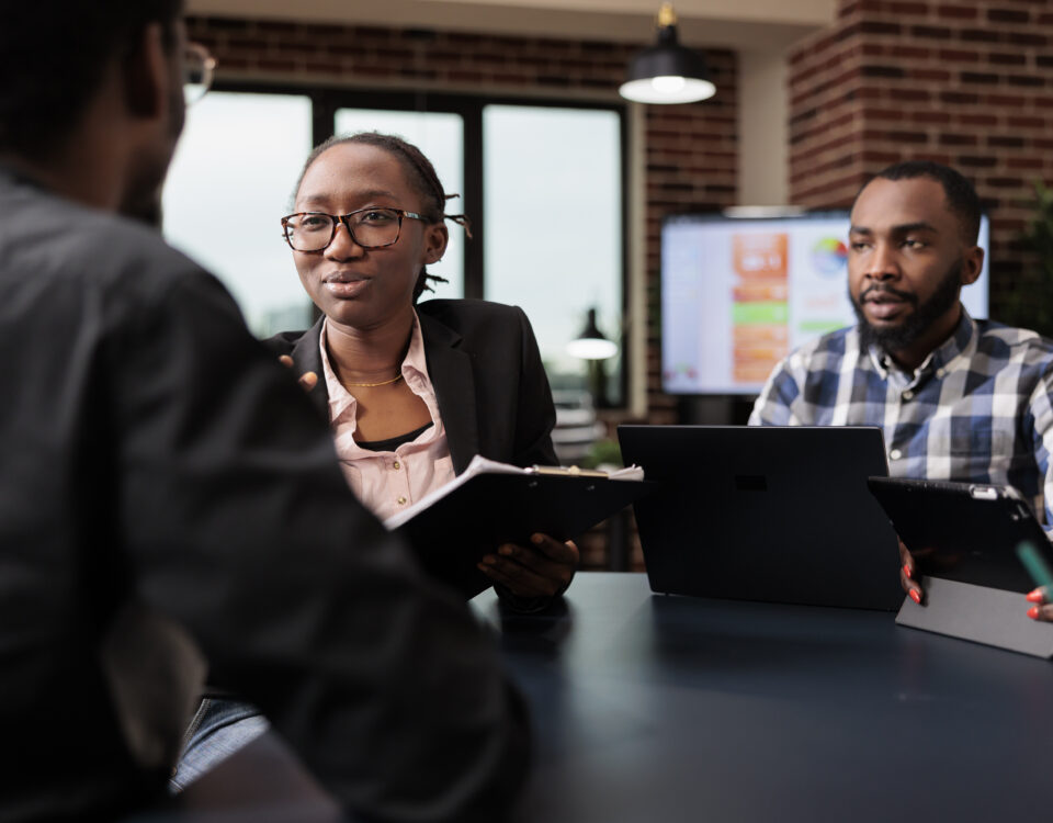 A group of people on a panel table analyzing a document - How to Conduct a Great Employee Reference Check - BizEdge blog
