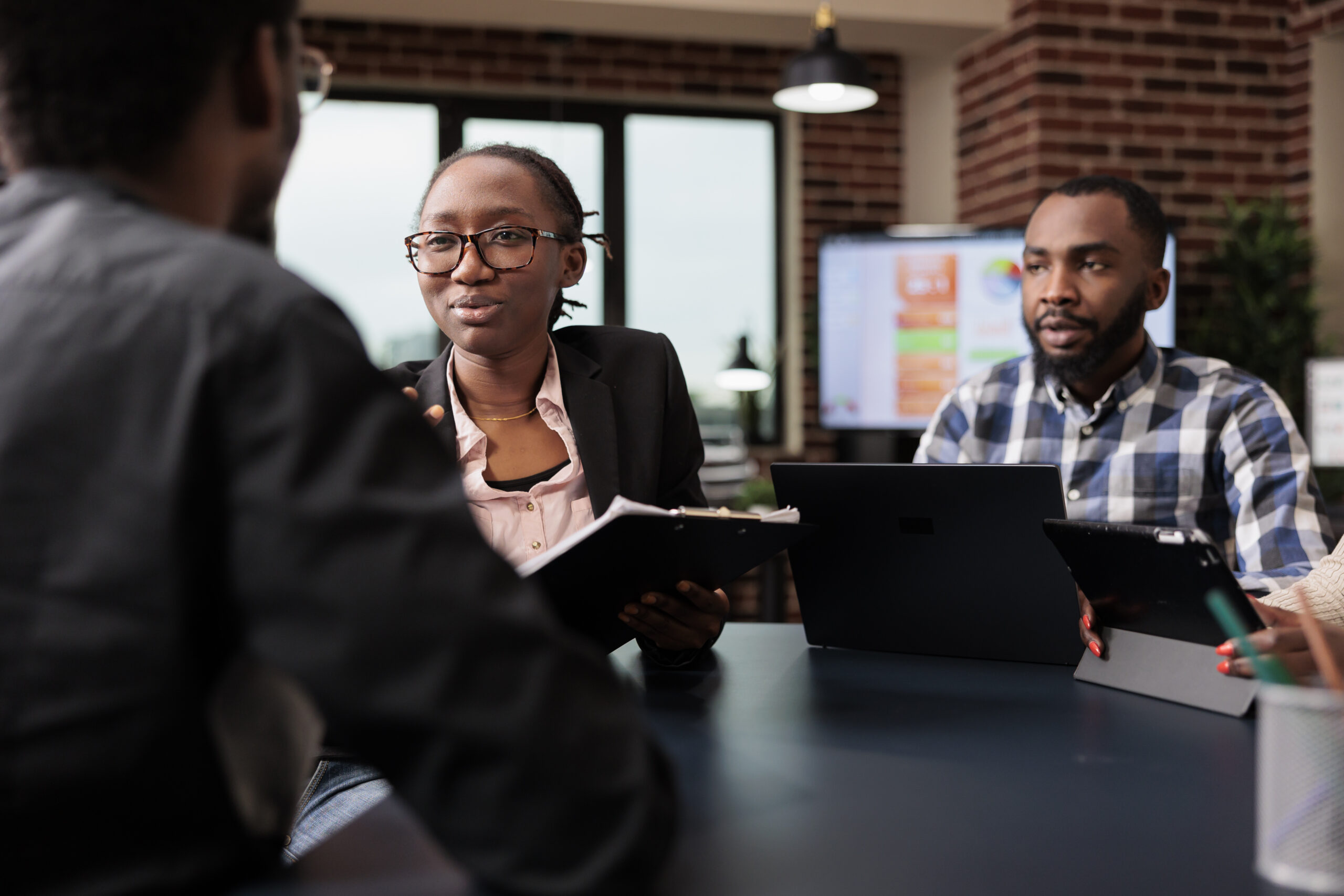 A group of people on a panel table analyzing a document - How to Conduct a Great Employee Reference Check - BizEdge blog