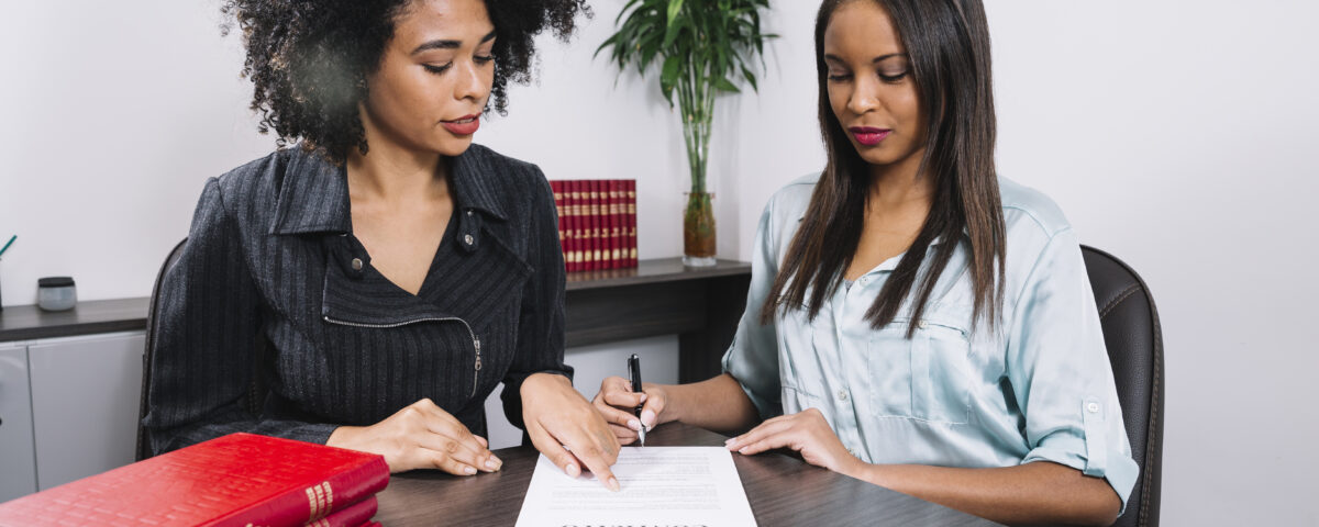 A woman pointing at a document to another lady - Payroll Compliance - BizEdge blog