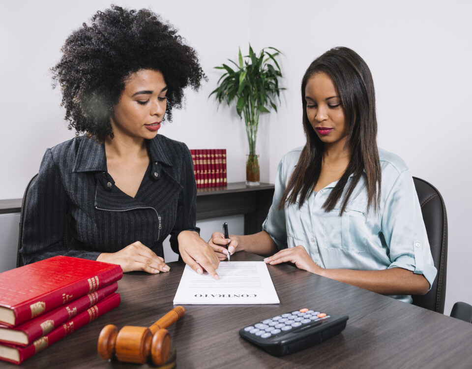 A woman pointing at a document to another lady - Payroll Compliance - BizEdge blog