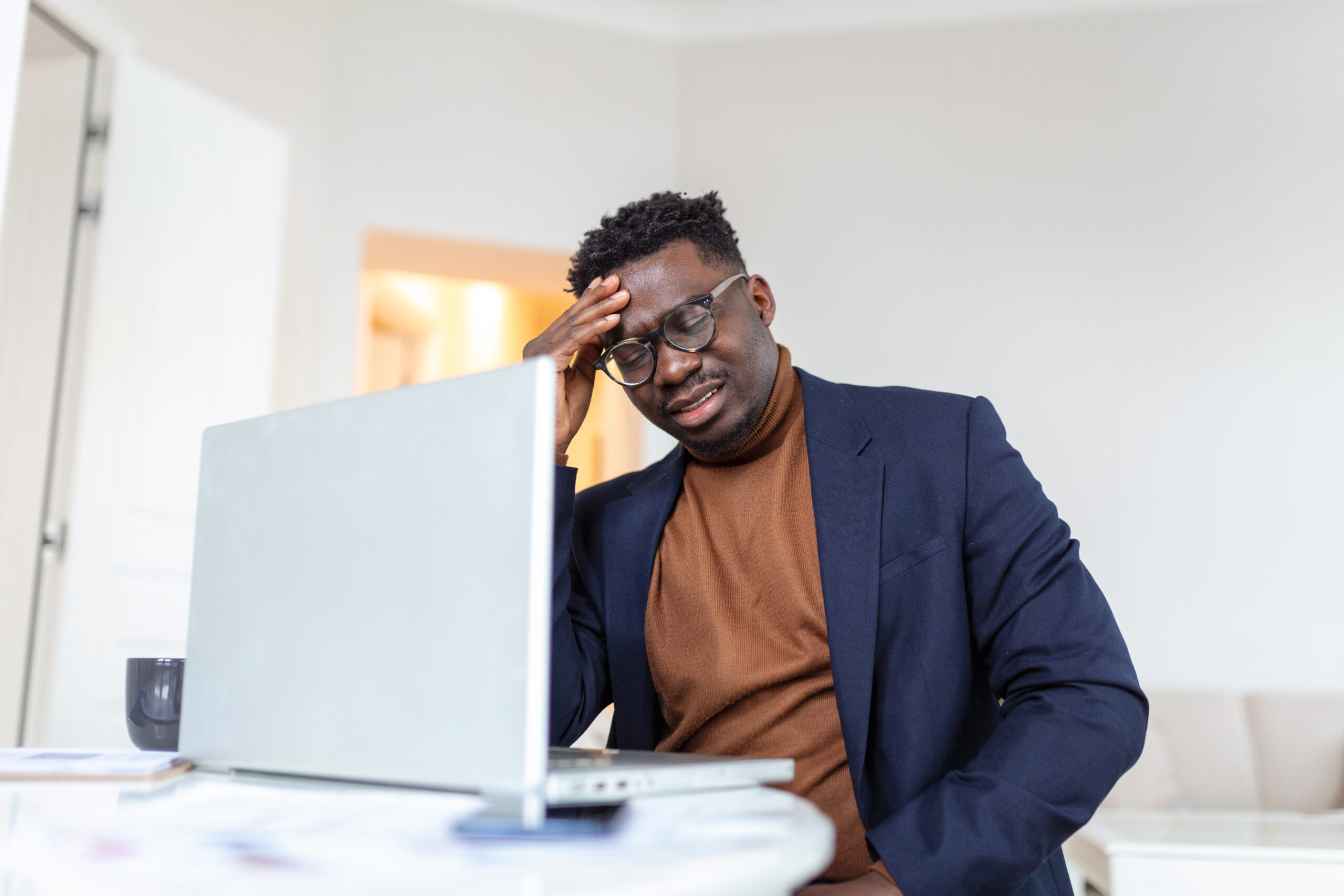 A picture of a stressed man in front of his laptop - How to Manage Employee Downtime Without Losing Productivity - BizEdge blog