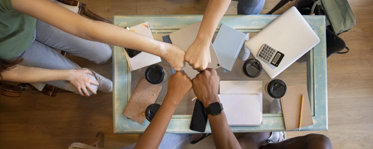 A picture of a group of people fist bumping - 6 Proven Ways to Build a Thriving Workplace Culture - BizEdge blog