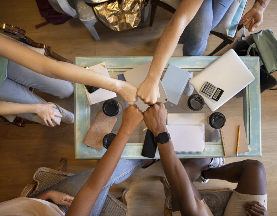 A picture of a group of people fist bumping - 6 Proven Ways to Build a Thriving Workplace Culture - BizEdge blog