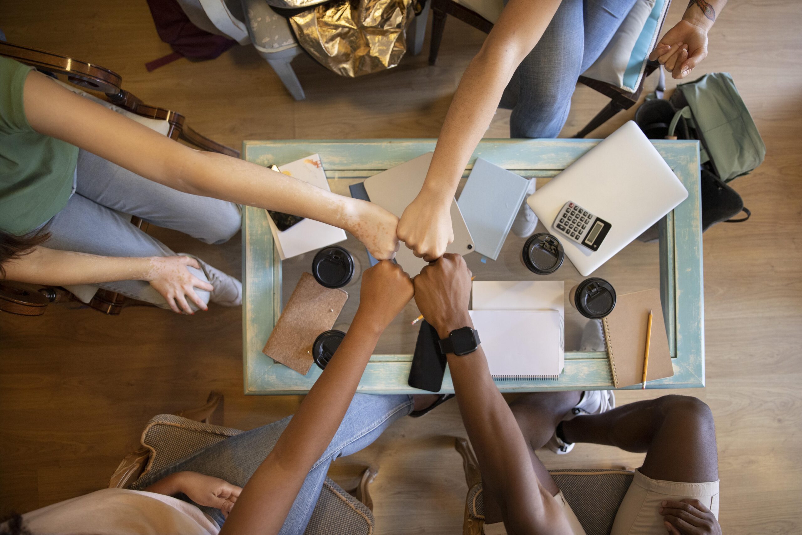 A picture of a group of people fist bumping - 6 Proven Ways to Build a Thriving Workplace Culture - BizEdge blog