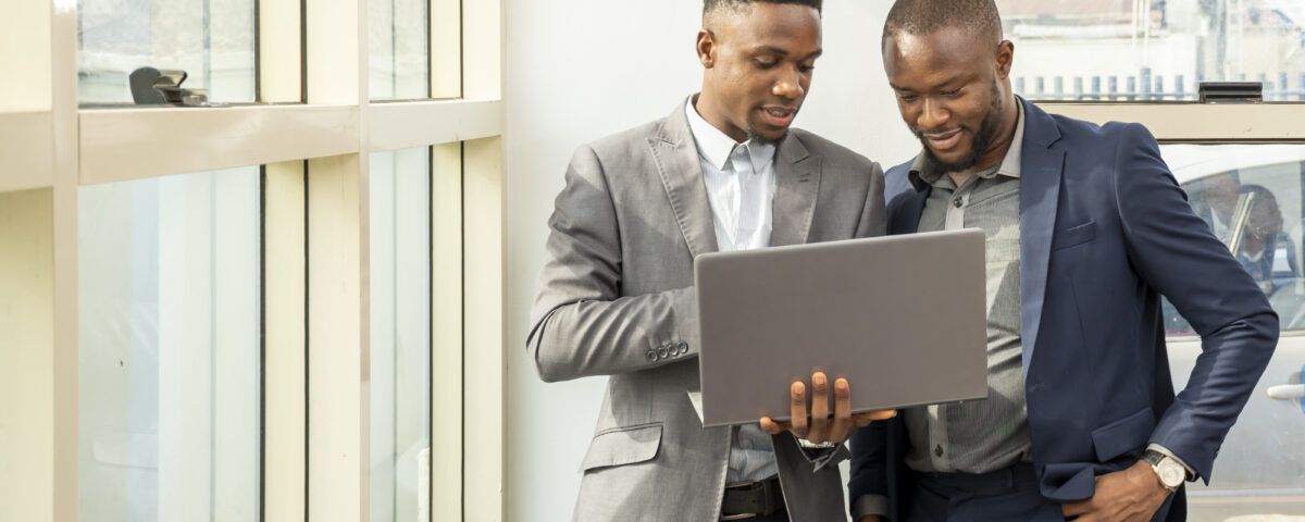 Two men viewing something on laptop - Tax Health Report -BizEdge blog