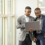Two men viewing something on laptop - Tax Health Report -BizEdge blog