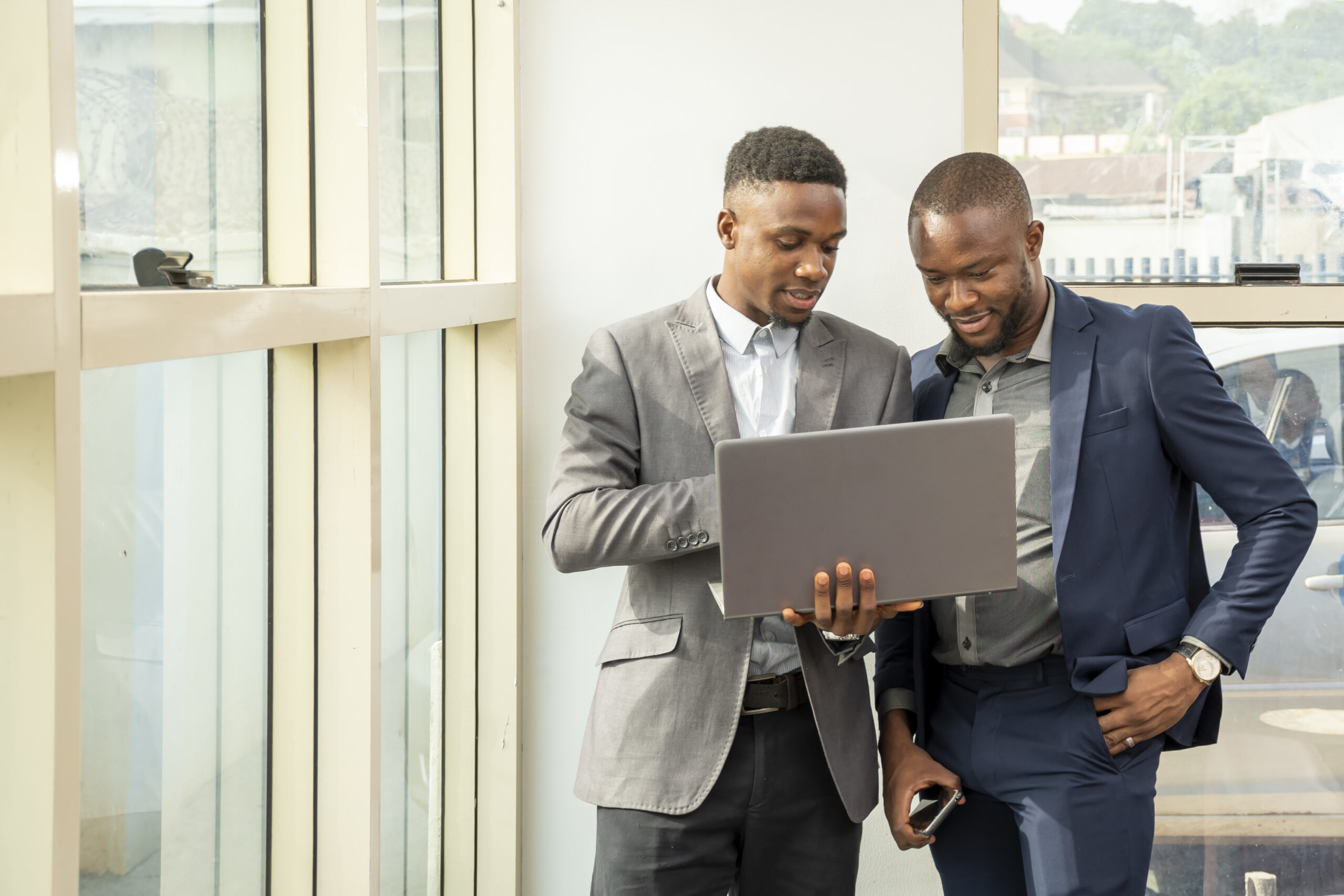 Two men viewing something on laptop - Tax Health Report -BizEdge blog