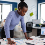 a lady with analyzing several reports - Managing multiple projects - BizEdge blog