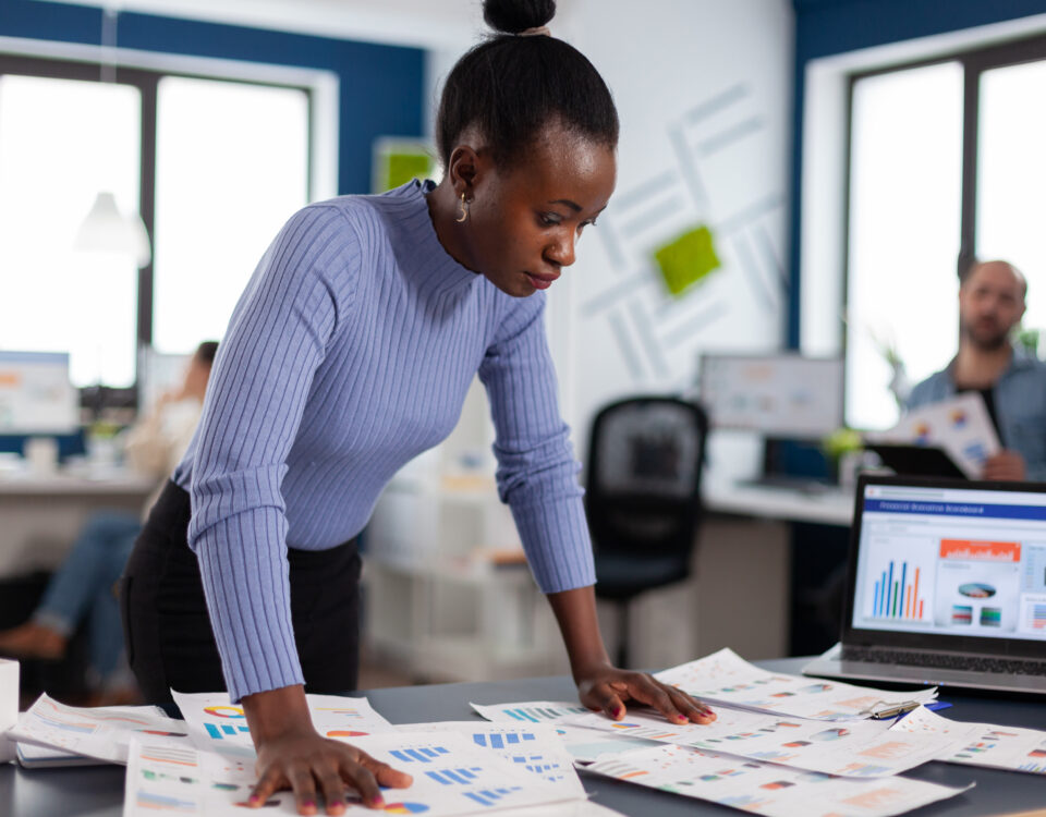 a lady with analyzing several reports - Managing multiple projects - BizEdge blog