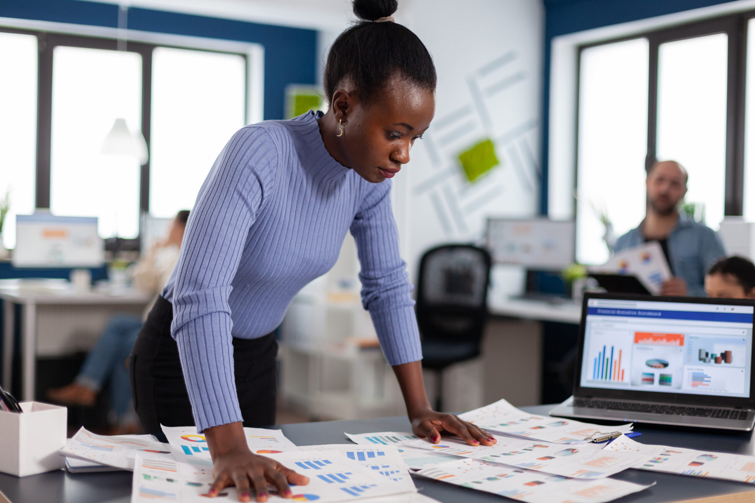 a lady with analyzing several reports - Managing multiple projects - BizEdge blog