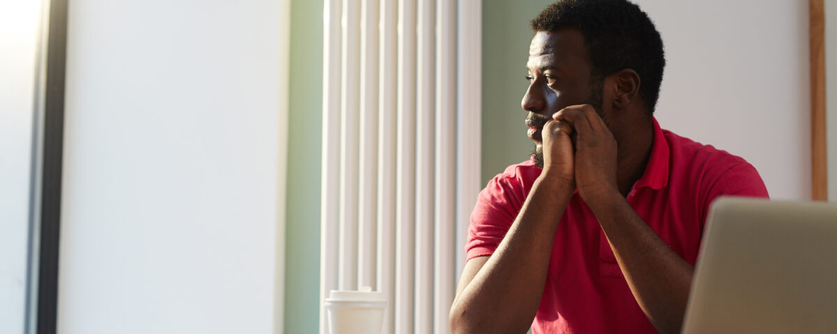 An employee looking through window on sunny day while sitting by desk in office - Employer branding - BizEdge blog