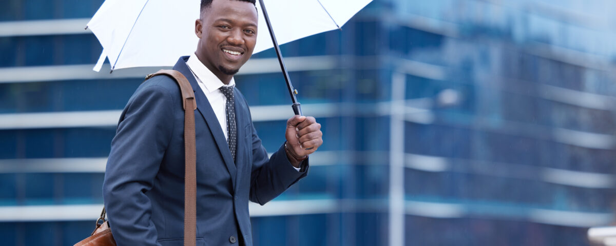 a man with umbrella going to work - rainy season in nigeria- BizEdge blog