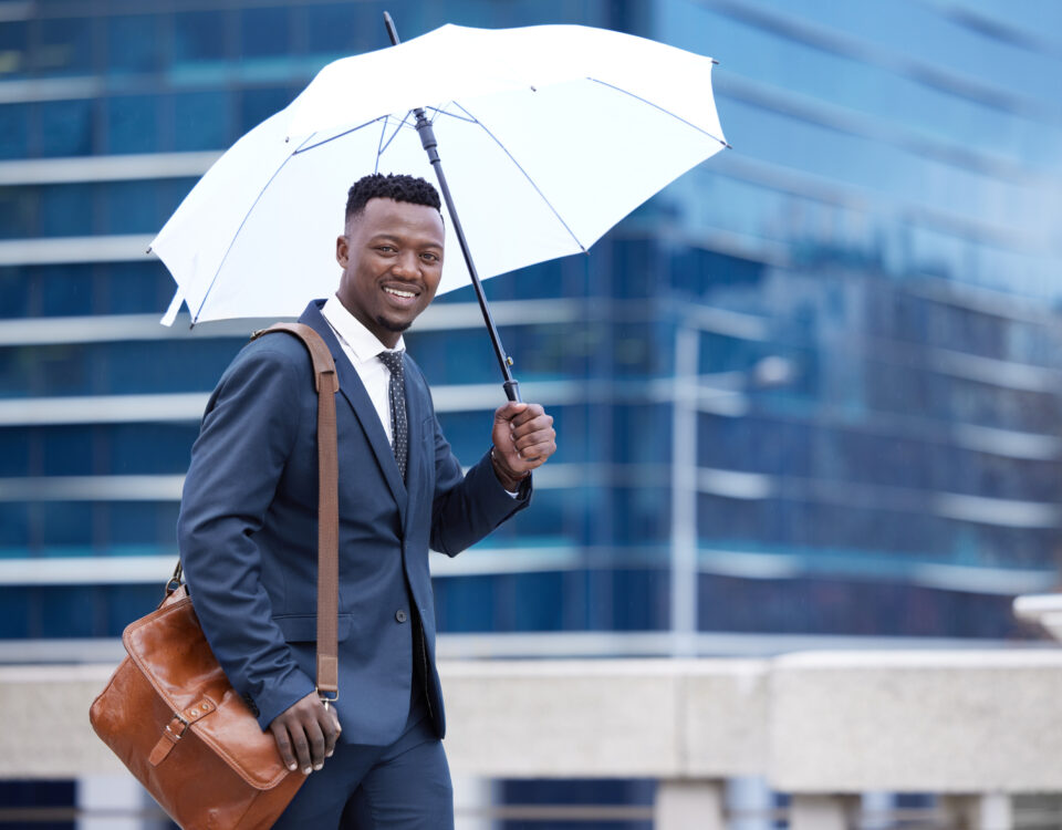 a man with umbrella going to work - rainy season in nigeria- BizEdge blog