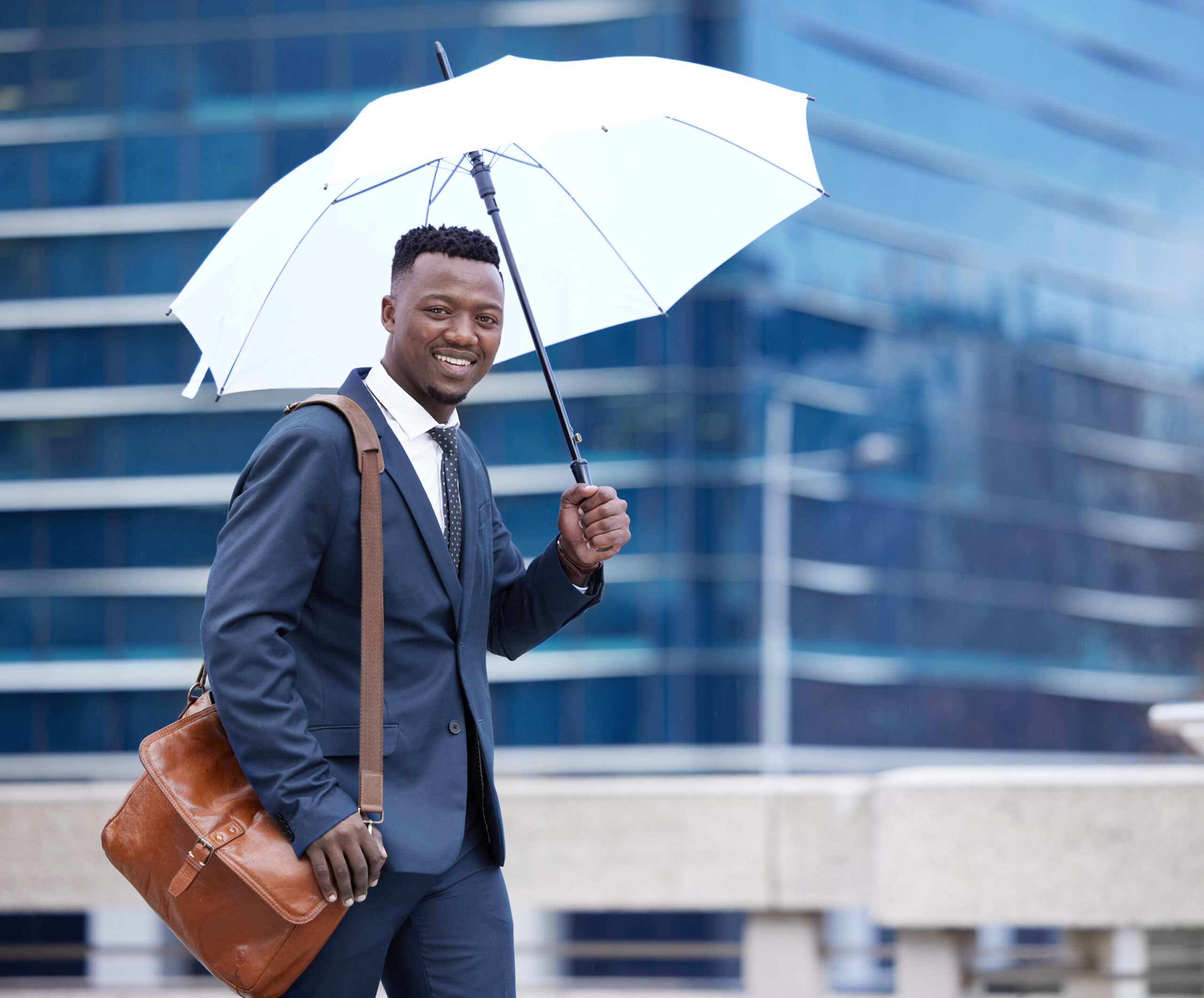 a man with umbrella going to work - rainy season in nigeria- BizEdge blog