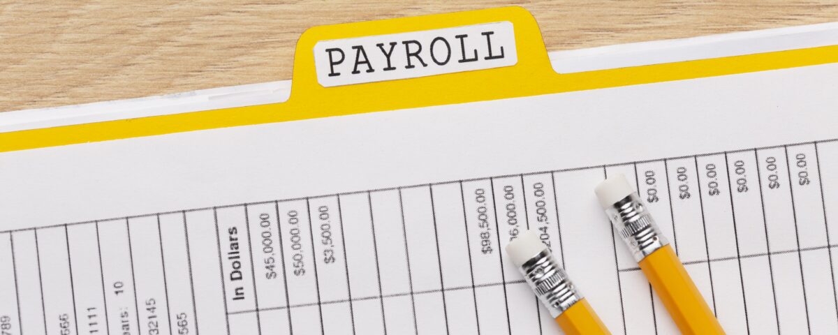 a picture of a payslip with a pen - payroll reconciliation - BizEdge blog