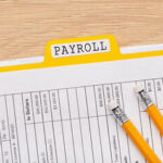 a picture of a payslip with a pen - payroll reconciliation - BizEdge blog