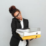 a woman carrying a set of files on her hand - Manual HR processes - BizEdge blog