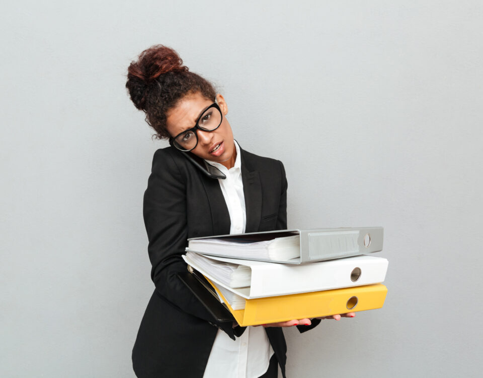 a woman carrying a set of files on her hand - Manual HR processes - BizEdge blog