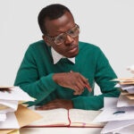 a man on his desk scanning through files- automate hr processes - BizEdge blog