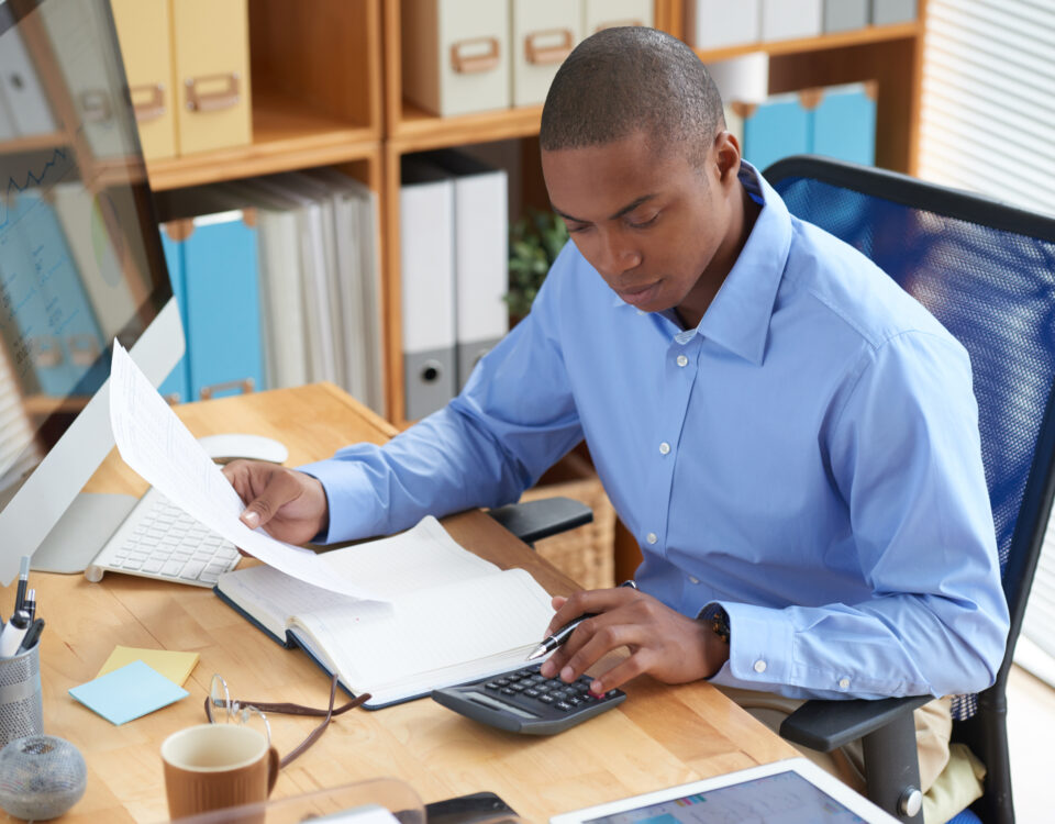 Businessman concentrated on work with financial document - TEC in salary - BizEdge blog