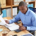 Businessman concentrated on work with financial document - TEC in salary - BizEdge blog