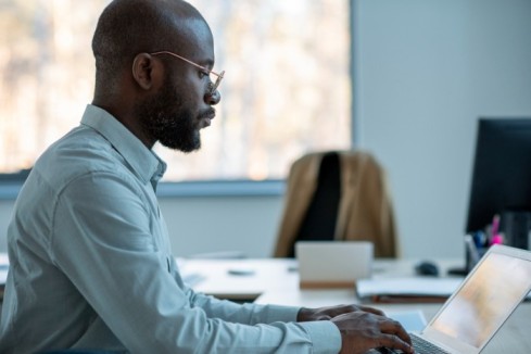 company employee standing in his office space while using his tablet - BizEdge v2 - BizEdge blog