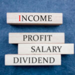 a jenga stick wood that has the word income, profit, salary and dividend written on it - salary structure - BizEdge blog
