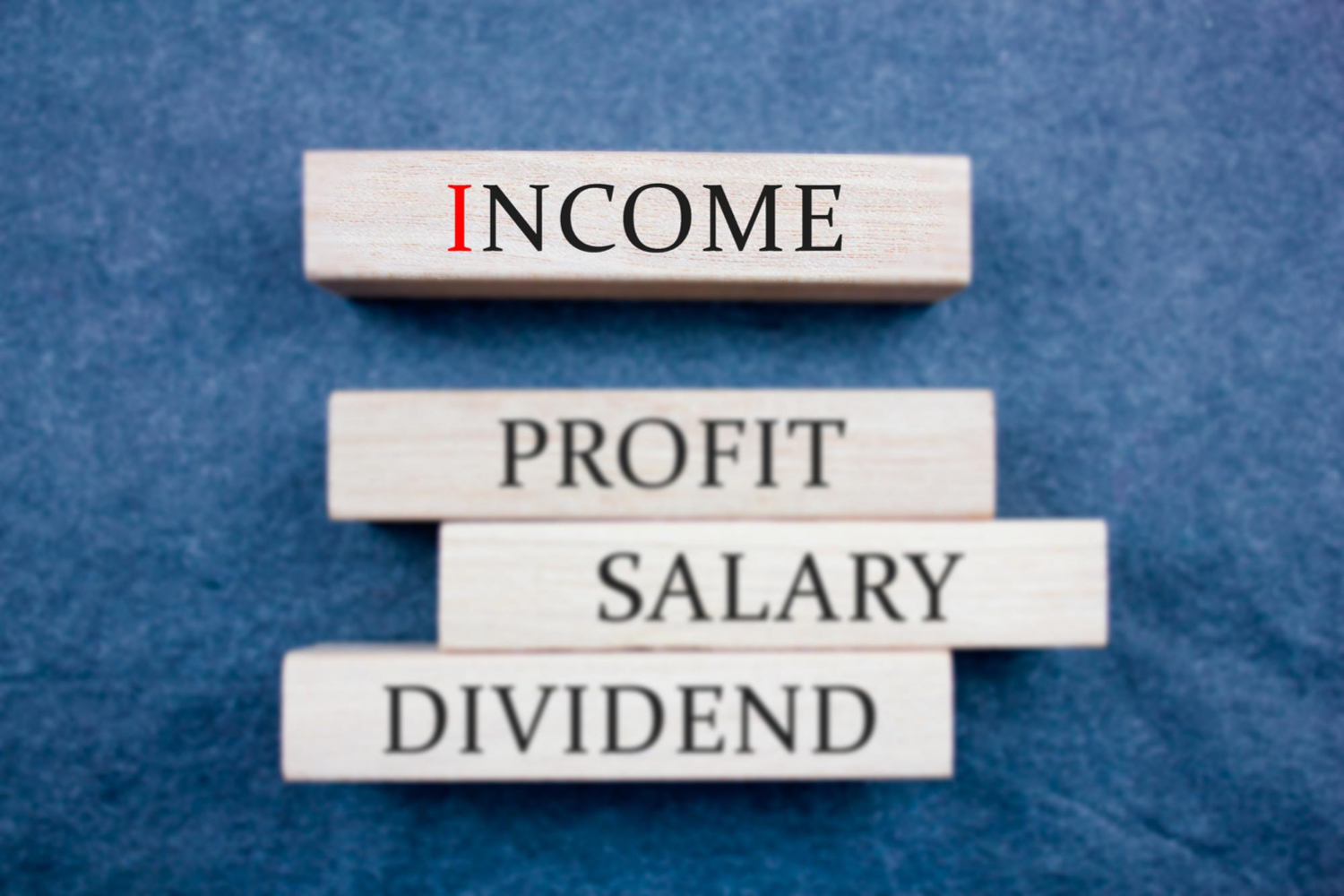 a jenga stick wood that has the word income, profit, salary and dividend written on it - salary structure - BizEdge blog