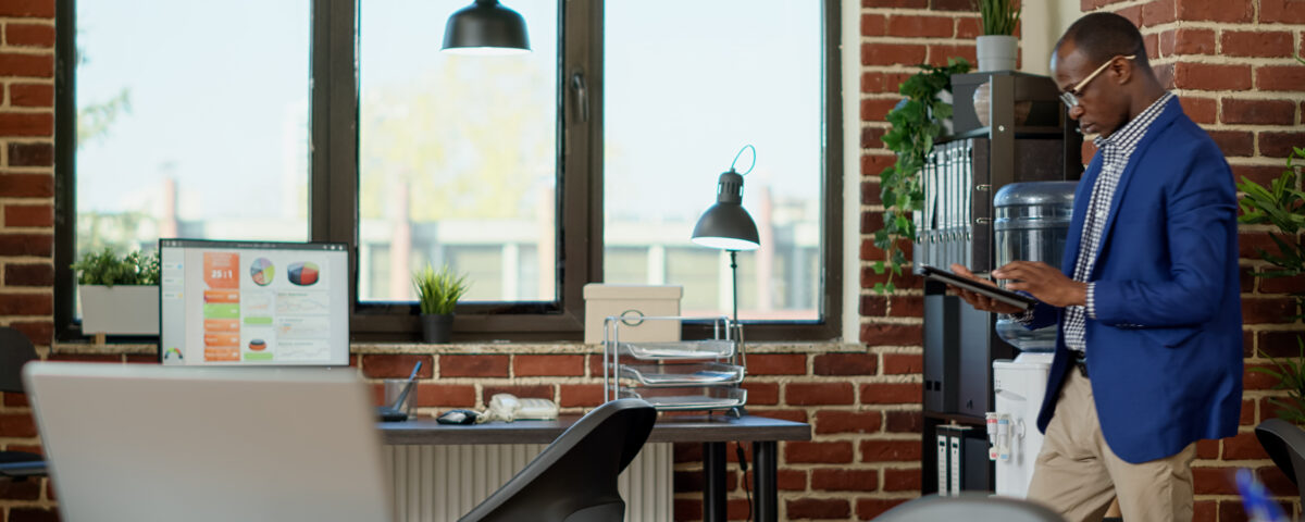 company employee standing in his office space while using his tablet - BizEdge v2 - BizEdge blog