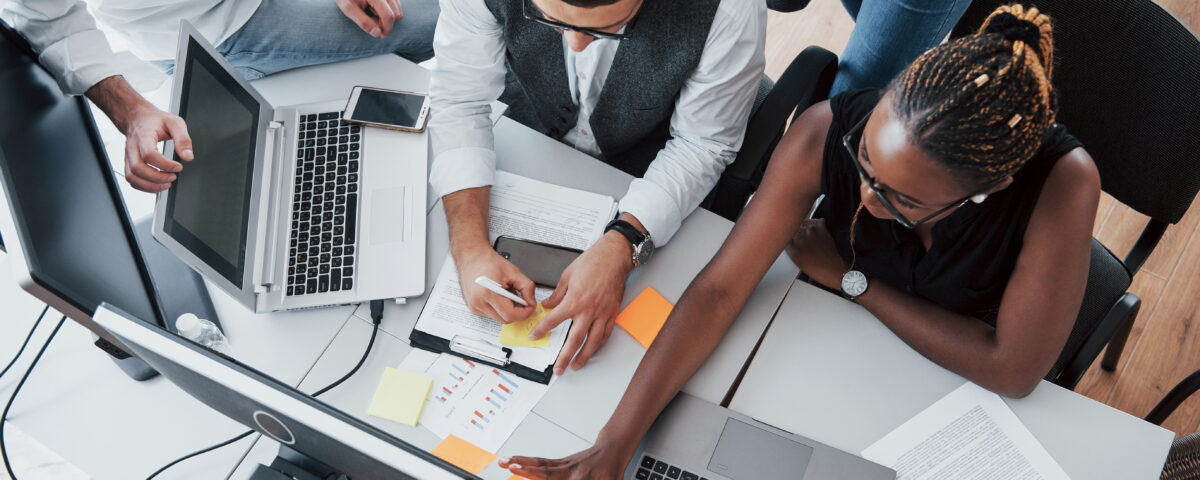 group of people working on the same desk - build future ready teams - BizEdge blog