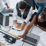 group of people working on the same desk - build future ready teams - BizEdge blog