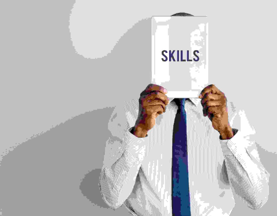 a man holding a pamphlet saying skills written on it - skills gap - BizEdge blog