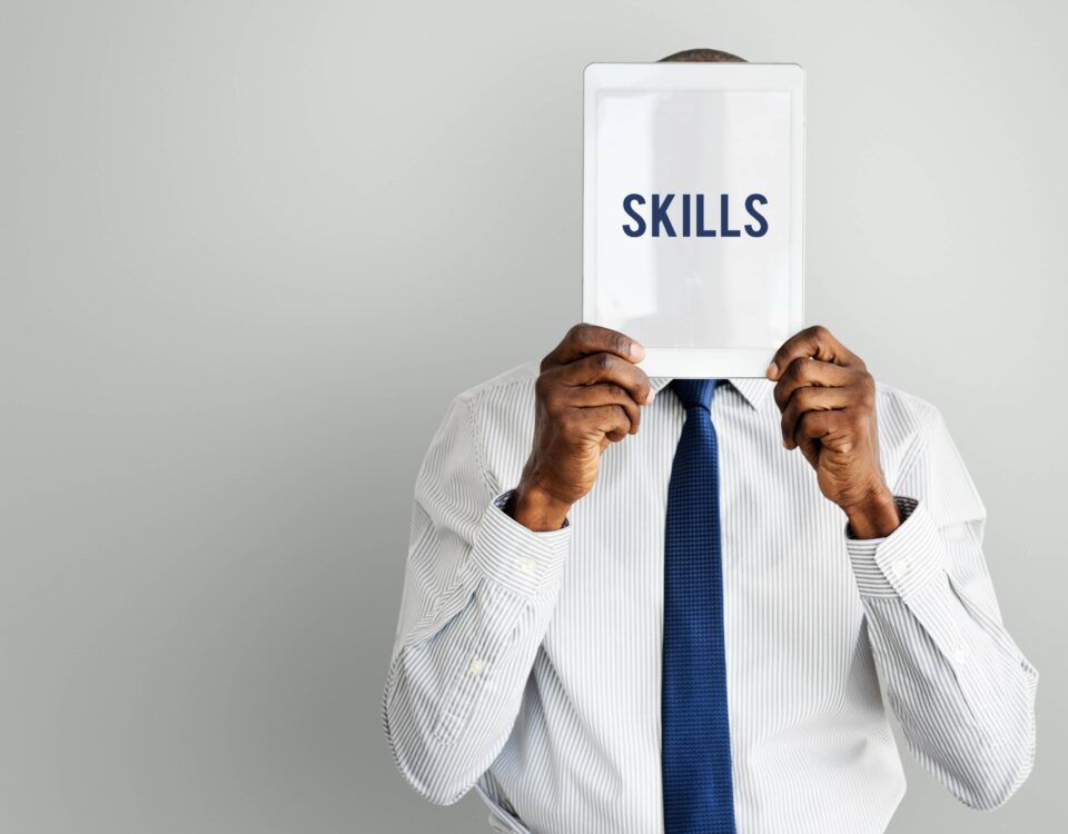 a man holding a paper with the word skills written on it - skills gap - BizEdge blog