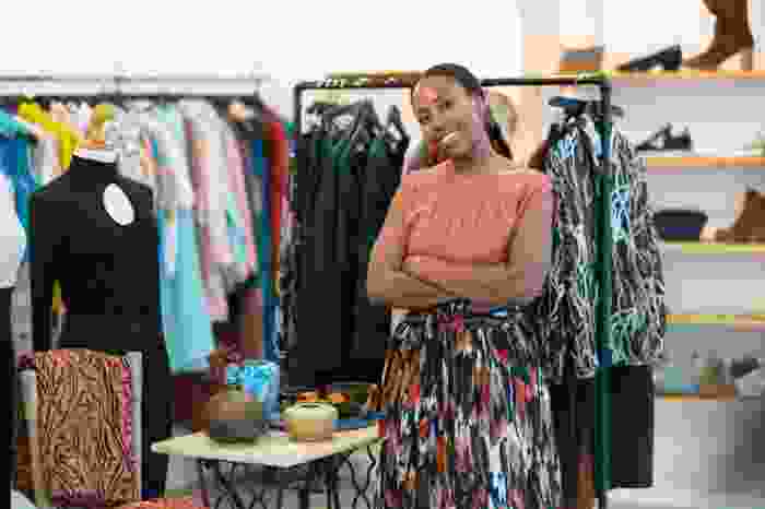 a woman smiling in her clothing brand shop - new nigeria tax act 2025 - BizEdge blog