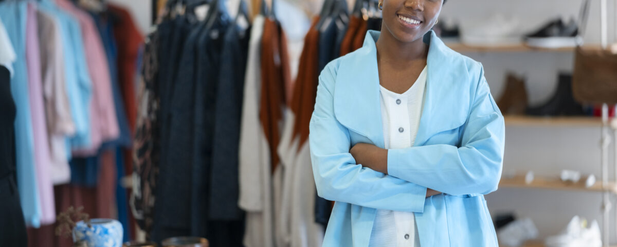 a woman smiling in her clothing brand shop - new nigeria tax act 2025 - BizEdge blog