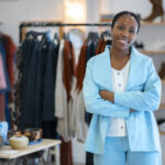 a woman smiling in her clothing brand shop - new nigeria tax act 2025 - BizEdge blog