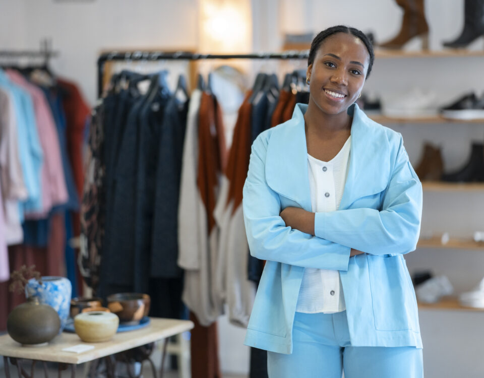 a woman smiling in her clothing brand shop - new nigeria tax act 2025 - BizEdge blog